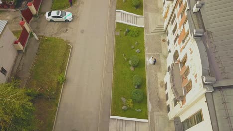 newlywed-couple-hugs-near-building-on-street-aerial-view