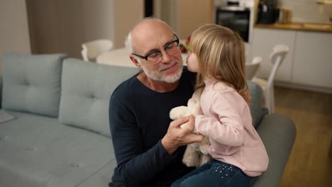 Little-granddaughter-give-a-little-kiss-to-elder-grandfather-at-home