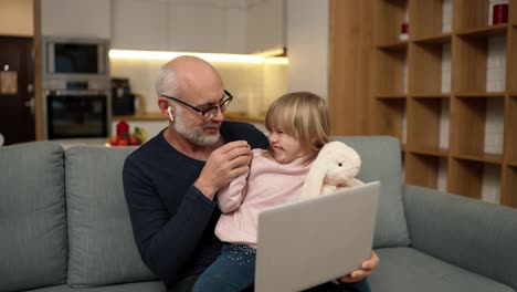 Grandfather-and-pretty-granddaughter-watching-something-together-by-laptop