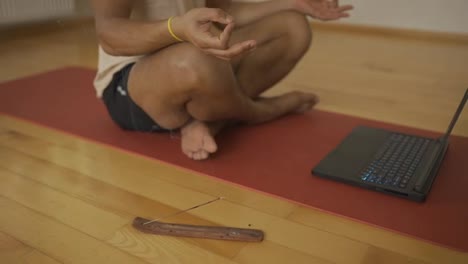 He-sticks-his-fingers-together-and-meditates-in-front-laptop-with-aroma-stick