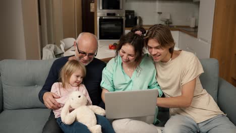 Children-and-grandpa-are-smiling-while-using-a-laptop