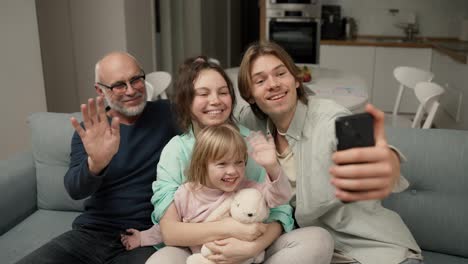 Grandfather-and-grandchildren-are-having-fun-to-make-selfie-or-video-call-to-family-with-smartphone