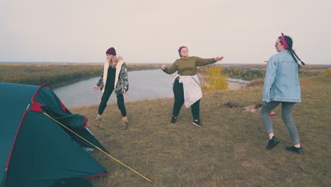 young-women-dance-spending-time-at-campsite-on-green-hill