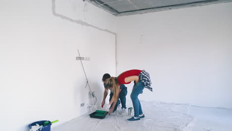 happy-man-with-pretty-wife-begins-painting-white-room-wall