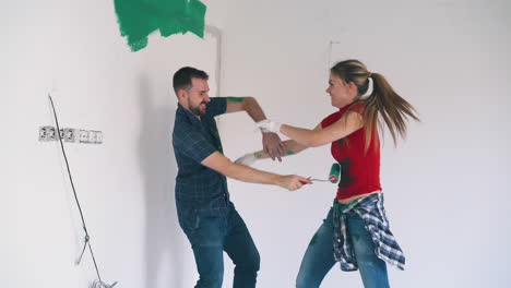 couple-has-fun-painting-each-other-at-construction-in-room