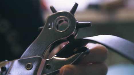 Skilled-tailor-makes-holes-with-special-punch-pliers
