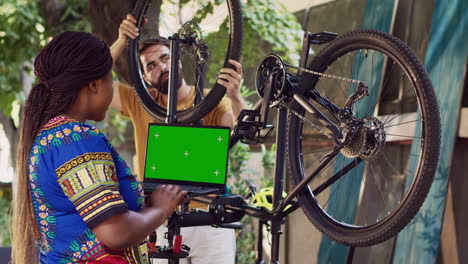 Couple-repairs-bike-with-isolated-laptop