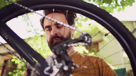 Man-examining-bicycle-wheel-for-damages