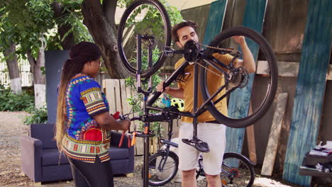 Couple-repair-bicycle-with-tools-in-yard
