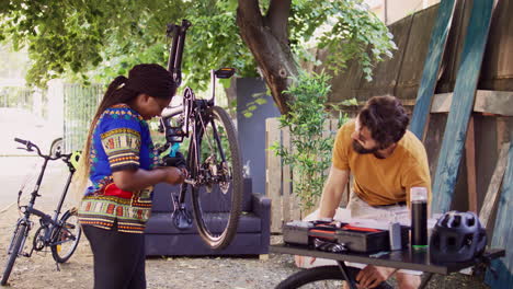 Couple-using-equipment-to-fix-bicycle