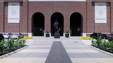 Bronze-sculpture-of-Nile-Kinnick-at-Kinnick-Stadium-on-the-campus-of-the-University-of-Iowa-in-Iowa-City,-Iowa-with-gimbal-video-walking-forward