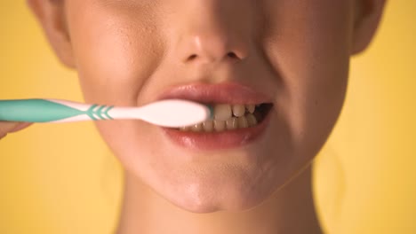 Kaukasische-Frau-Putzt-Ihre-Zähne-Mit-Zahnbürste,-Nahaufnahme-Des-Mundes,-Chroma-Hintergrund,-Weibliches-Junges-Modell-Mit-Weißer-Haut