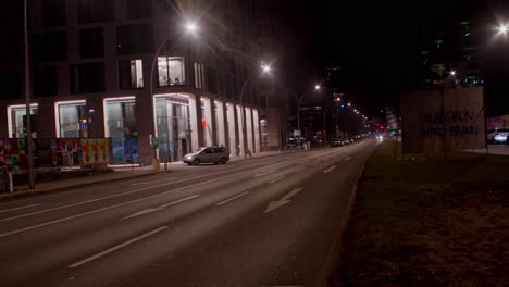 Establishing-wide-shot-of-Berlin-street-road-at-night-with-cars-driving-by