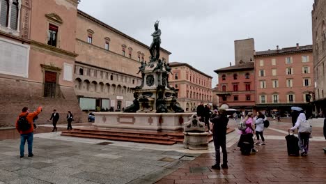 Tourists-Taking-Photos-At-Fountain-of-Neptune-With-Palazzo-Re-Enzo-In-Background-In-Bologna-,Italy