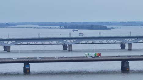 Panorama-of-the-Moerdijk-bridges-in-the-Netherlands,-connecting-the-island-of-Dordrecht-with-the-Dutch-province-of-North-Brabant-via-Hollands-Diep,-on-which-cars-pass