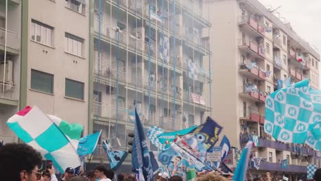 Pov-shot-showing-waving-flags-of-SSC-Napoli-after-win-of-Championship-in-road-in-city---decorated-balcony-of-apartment-blocks
