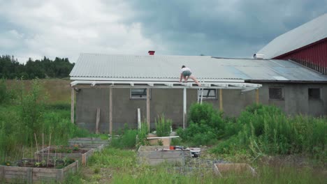 Man-Installing-Roof-Extension-Outside-The-House-In-Rural-Landscape