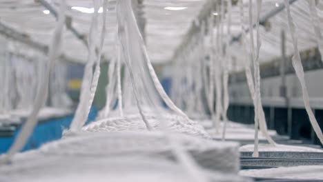 panoramic-cinematic-shot-cotton-thread-manufacturing-in-a-textile-oil-factory,-Organic-cotton-yarn-used-for-sustainable-eco-friendly-yarns-fabric-decentralised-production