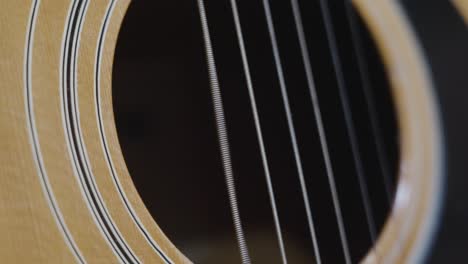 Extreme-slo-mo-clip-over-the-sound-hole-of-an-old-acoustic