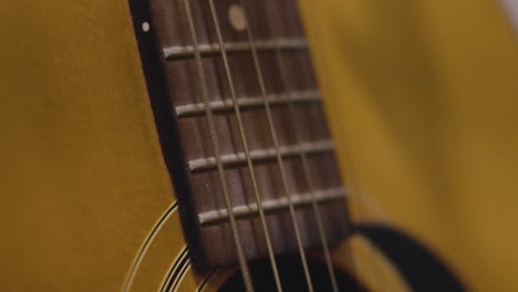 Plucking-various-strings-on-an-old-guitar-in-slow-motion