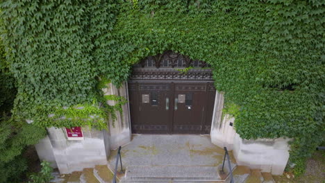 Aerial-rising-tilt-view-in-front-of-the-door-to-the-Stuart-Hall-at-the-University-of-Chicago,-USA