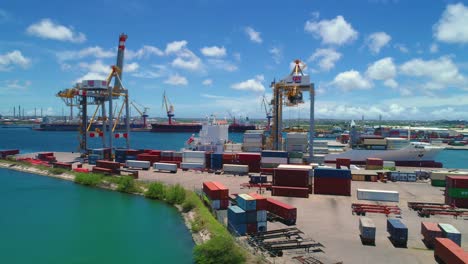 Container-crane-port-with-boat-docked,-blue-sky-sunny-day-on-the-Caribbean-island-of-Curacao