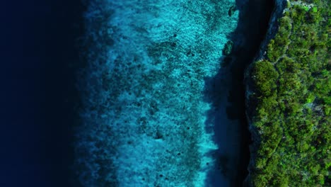 La-Profunda-Caída-De-Agua-Azul-Oscuro-Conduce-Al-Arrecife-Interior-En-El-Borde-Del-Acantilado-De-Una-Isla-Tropical,-Espacio-De-Copia