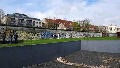 Statische-Aufnahme-Von-Menschen-In-Der-Nähe-Der-Mit-Graffiti-Versehenen-Berliner-Mauer,-Bernauer-Straße,-Berlin
