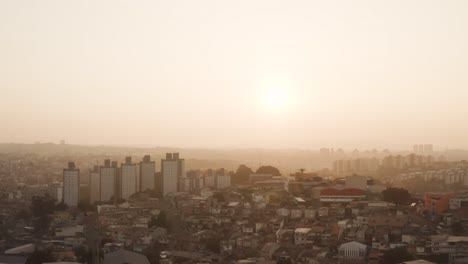 Cinematic-drone-shot-showing-Sao-Paulo-Cityscape-with-row-of-apartment-blocks-during-foggy-sunset-in-Brazil