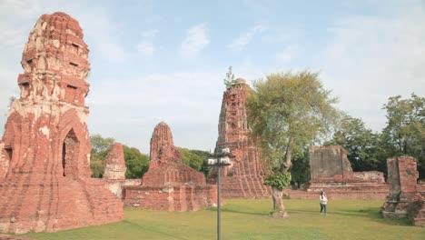 Tourist-Taking-Photos-of-Ayutthaya's-Thai-Temple-Ruins-in-Thailand-on-a-Sunny-Day