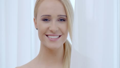 Hübsche-Lächelnde-Frau-Hinter-Weißem-Vorhang