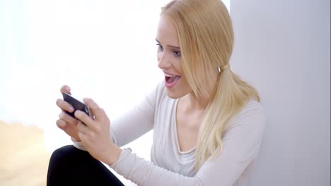 Excited-young-woman-reading-an-sms-on-her-mobile
