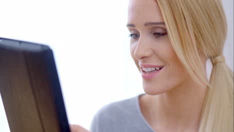 Happy-Blond-Girl-Using-her-Tablet-Computer