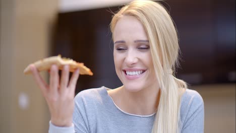 Young-woman-holding-a-slice-of-pizza