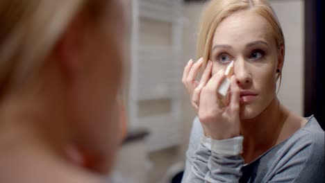 Pretty-Blond-Woman-Applying-Eyebrow-Makeup