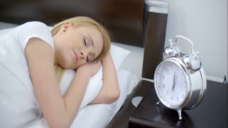 Lying-Woman-Turning-Off-an-Alarm-Clock