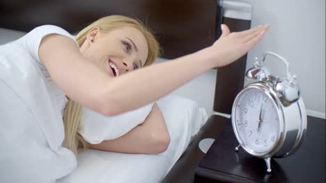 Lying-Woman-Turning-Off-an-Alarm-Clock