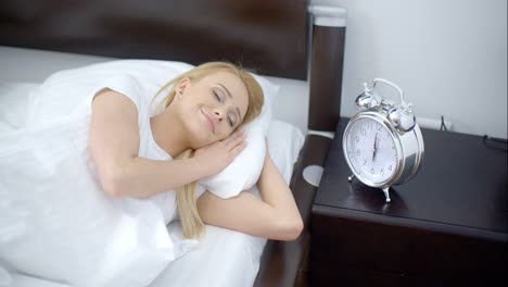 Pretty-Sleeping-Woman-with-Alarm-Clock-Next-to-Her