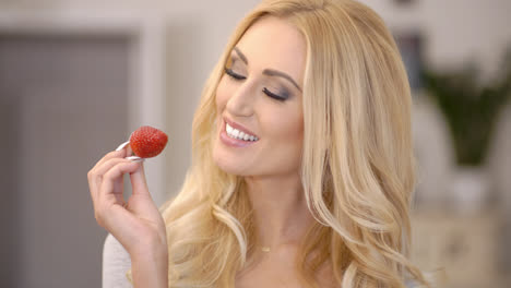 Gesunde-Attraktive-Blonde-Frau-Isst-Eine-Erdbeere