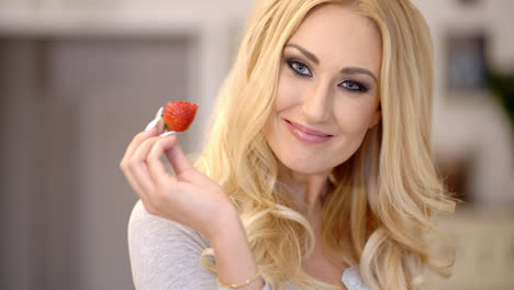 Gesunde-Attraktive-Blonde-Frau-Isst-Eine-Erdbeere