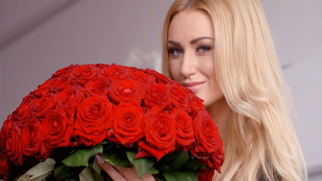 Blonde-Frau-Hält-Einen-Strauß-Frischer-Roter-Rosen