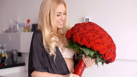 Happy-Woman-in-Nightwear-Holding-Red-Rose-Bouquet