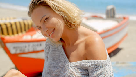 Mujer-Sonriente-Vistiendo-Un-Suéter-Gris-En-La-Playa