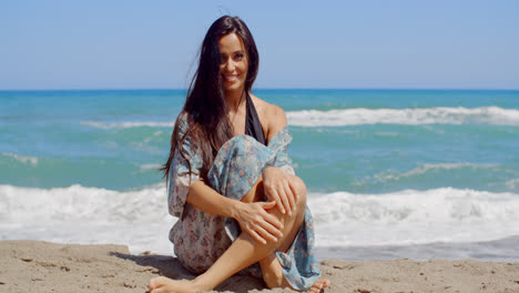 Smiling-Attractive-Woman-Sitting-on-the-Beach-Sand