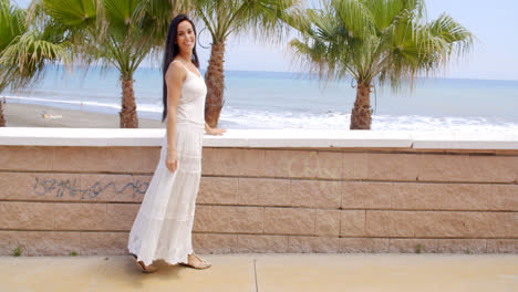 Woman-in-White-Dress-by-Wall-Overlooking-Beach