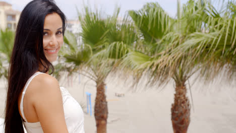 Brunette-Woman-Smiling-at-Camera-on-Tropical-Beach