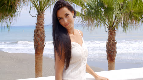 Mujer-Vestida-De-Blanco-Parada-En-Una-Playa-Tropical