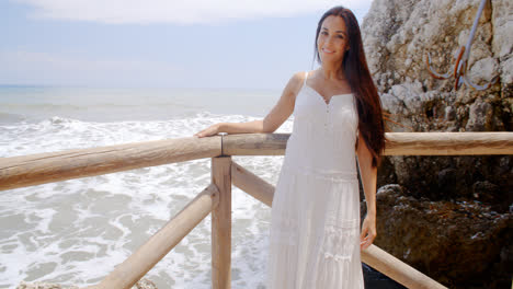 Young-Lady-in-White-Standing-at-Beach-Railings