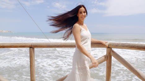 Lady-Holding-at-Beach-Railing-with-Air-Blown-Hair