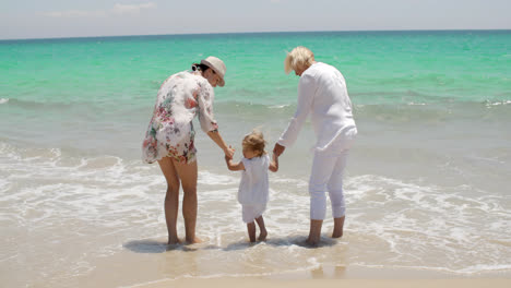 Oma-Und-Mama-Halten-Kleines-Mädchen-Am-Strand